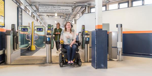a wheelchair user coming through the barriers