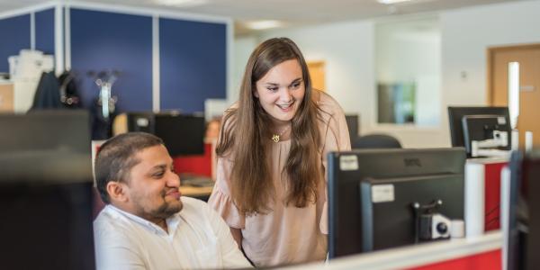 Change100 interns from Royal Berkshire Fire Service standing by a desk