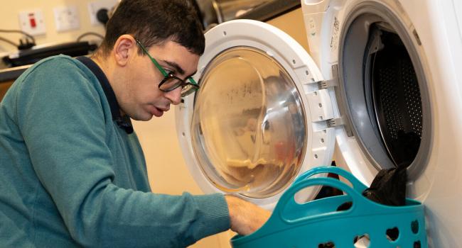 Jonathan using a washing machine at Eden Square