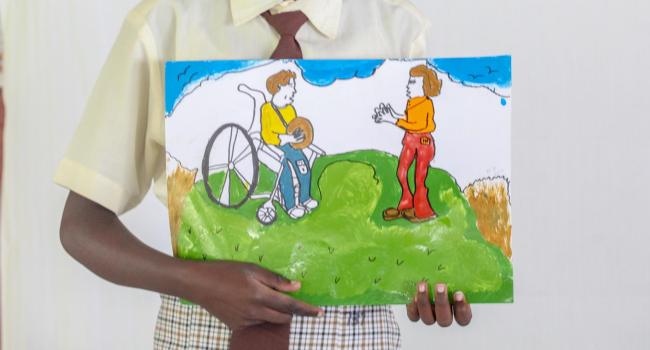 A student holding their painting