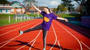 Olivia Breen on a running track standing in a star position with one leg in the air