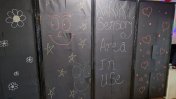 Black  tall standing  cushioned privacy screen with chalk  stars, hearts, and flower scribbles and writing saying sensory area in use