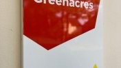 A branded Leonard Cheshire sign on wall saying 'Welcome to Greenacres' 