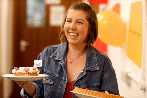 A woman holding two cakes