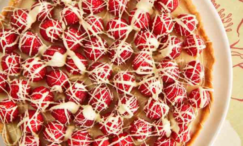 BerryWorld's raspberry and white chocolate tart presented on a white plate