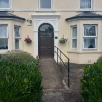 Front exterior with a black arched front door with hanging baskets either side and an accessible ramp leading up to it