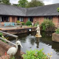 One story building surrounding a pond with a fountain and bridge with a pelican statue