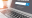 An open silver laptop with a job search engine window open in front of a sun lit window and plant pot
