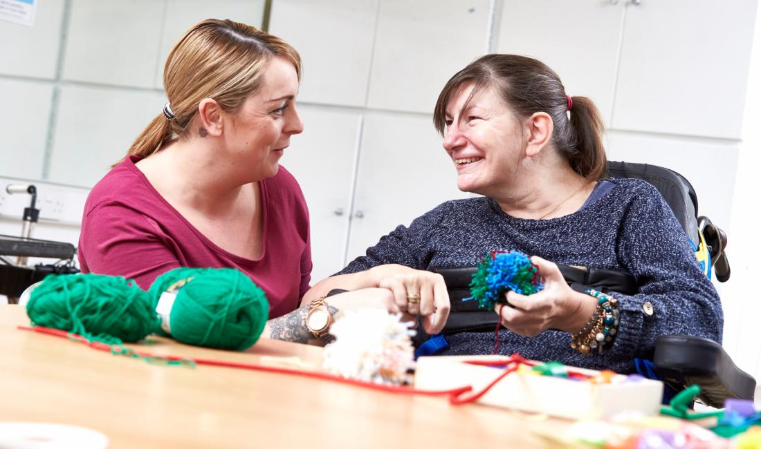 Resident and carer sewing