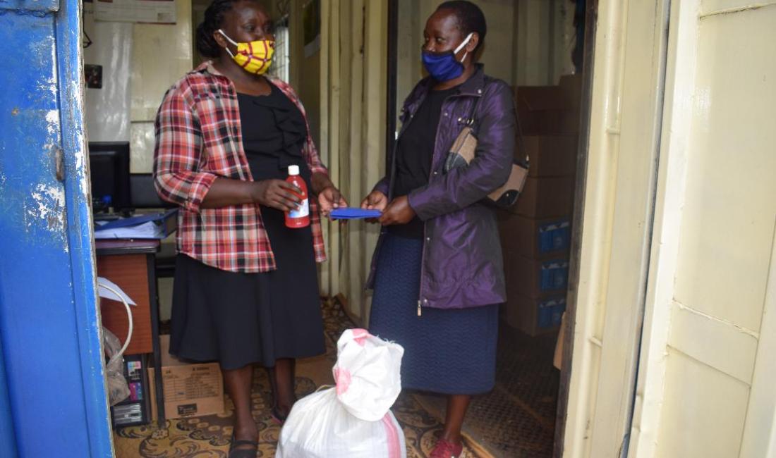Two women wearing face masks talking